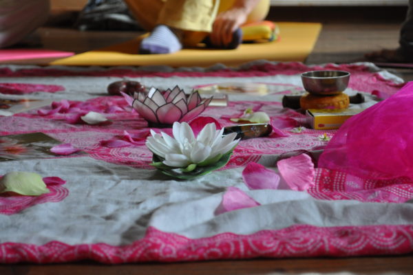Foto: Yoga-Mitte mit buntem Tuch und Blumendekoration